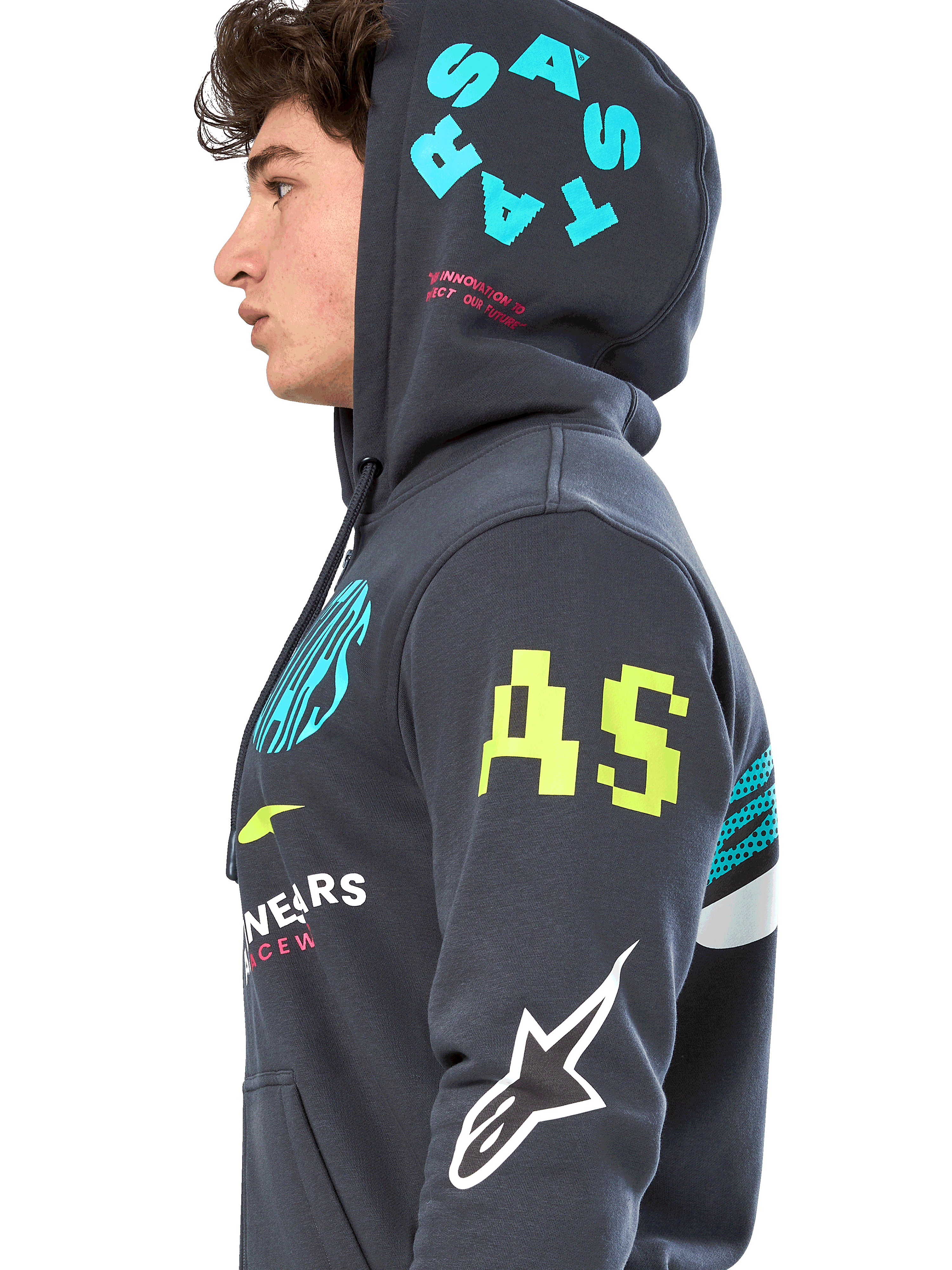 Alpinestars Variegate Hoodie, mörkgrå (Gunmetal) fleecehoodie med dragkedja, sidoprofil av modell, grafik med flera logotyper i neongult, ljusblått och vitt, 'AS'-logotyp på ärmen och 'STARS' på huvan, vardaglig motorsportinspirerad streetwear