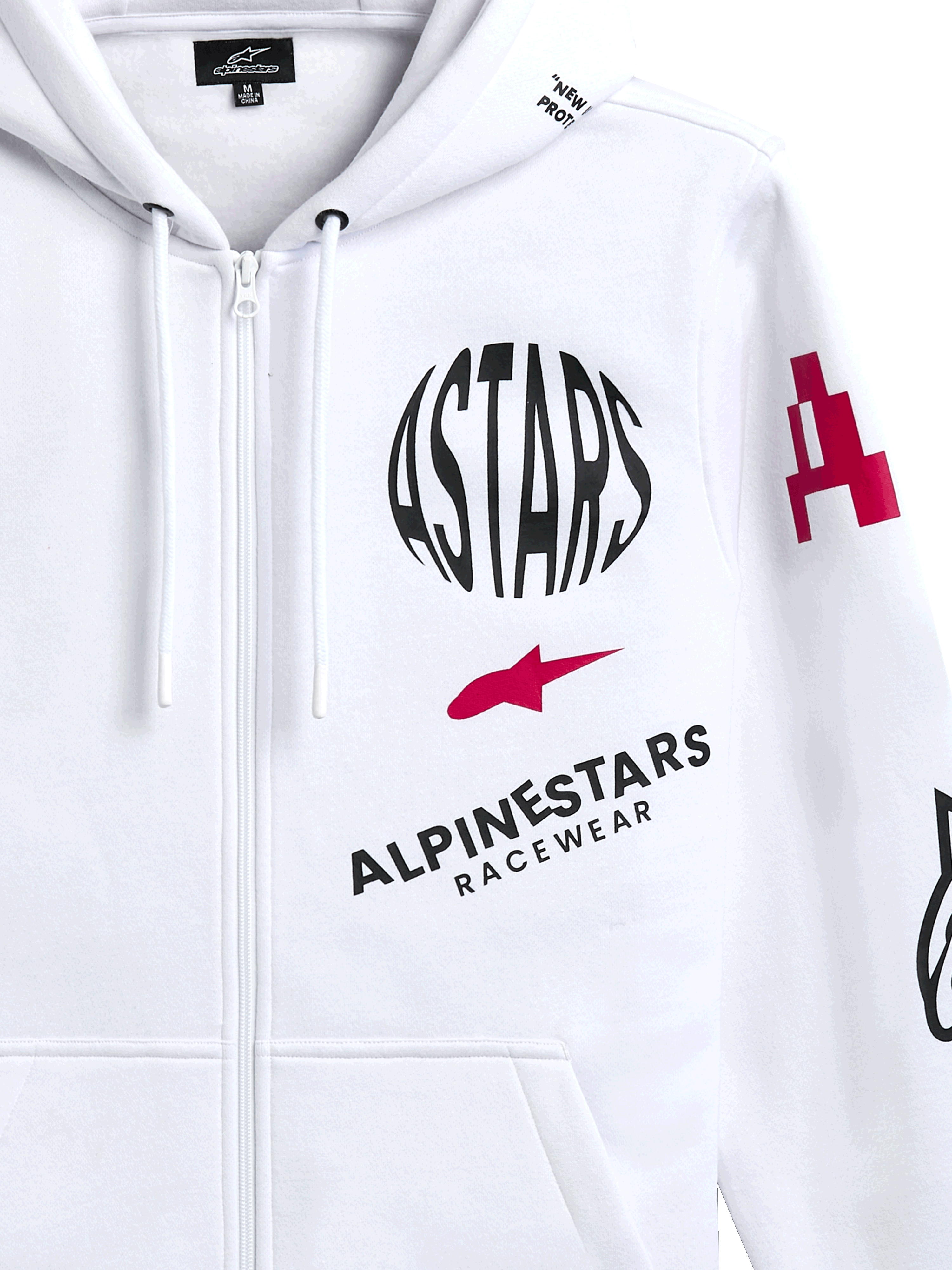 Alpinestars Variegate Hoodie, vit fleecehoodie med dragkedja fram, med cirkulär svart ASTARS-logotyp, röd stjärnsymbol och Alpinestars Racewear-märkning på bröstet, casual motorsport-streetwear