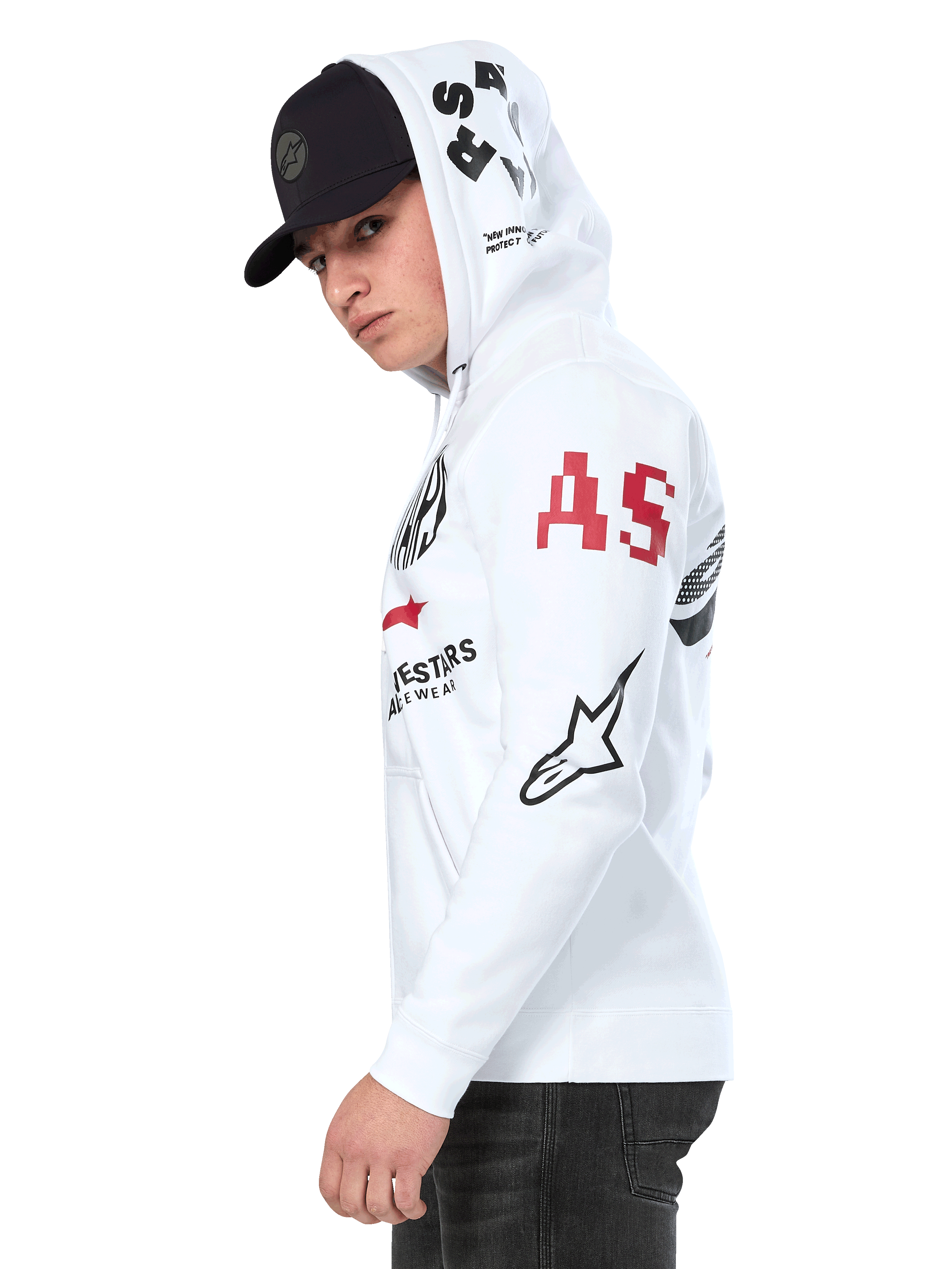 Alpinestars Variegate Hoodie, vit fleecehoodie med dragkedja framtill, grafik med flera logotyper på ärmarna och huvan med röda 'AS'-bokstäver och en svart stjärnlogotyp, bärs av en man med en svart keps, avslappnad motorsport-streetwear