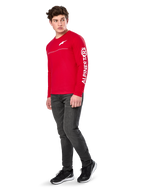 Alpinestars Committed CSF Tee, Long Sleeve T-Shirt, Red, featuring white Astars chest logo and Alpinestars sleeve branding, worn by a model with dark jeans and black sneakers, casual motorsport streetwear