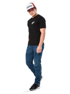 Alpinestars Formulate Csf Tee, kortärmad t-shirt, svart med vit Astars-logotyp på bröstet, bärs av en modell med blå jeans, en vinröd och vit keps och svarta sneakers, avslappnad motorsport-inspirerad streetwear