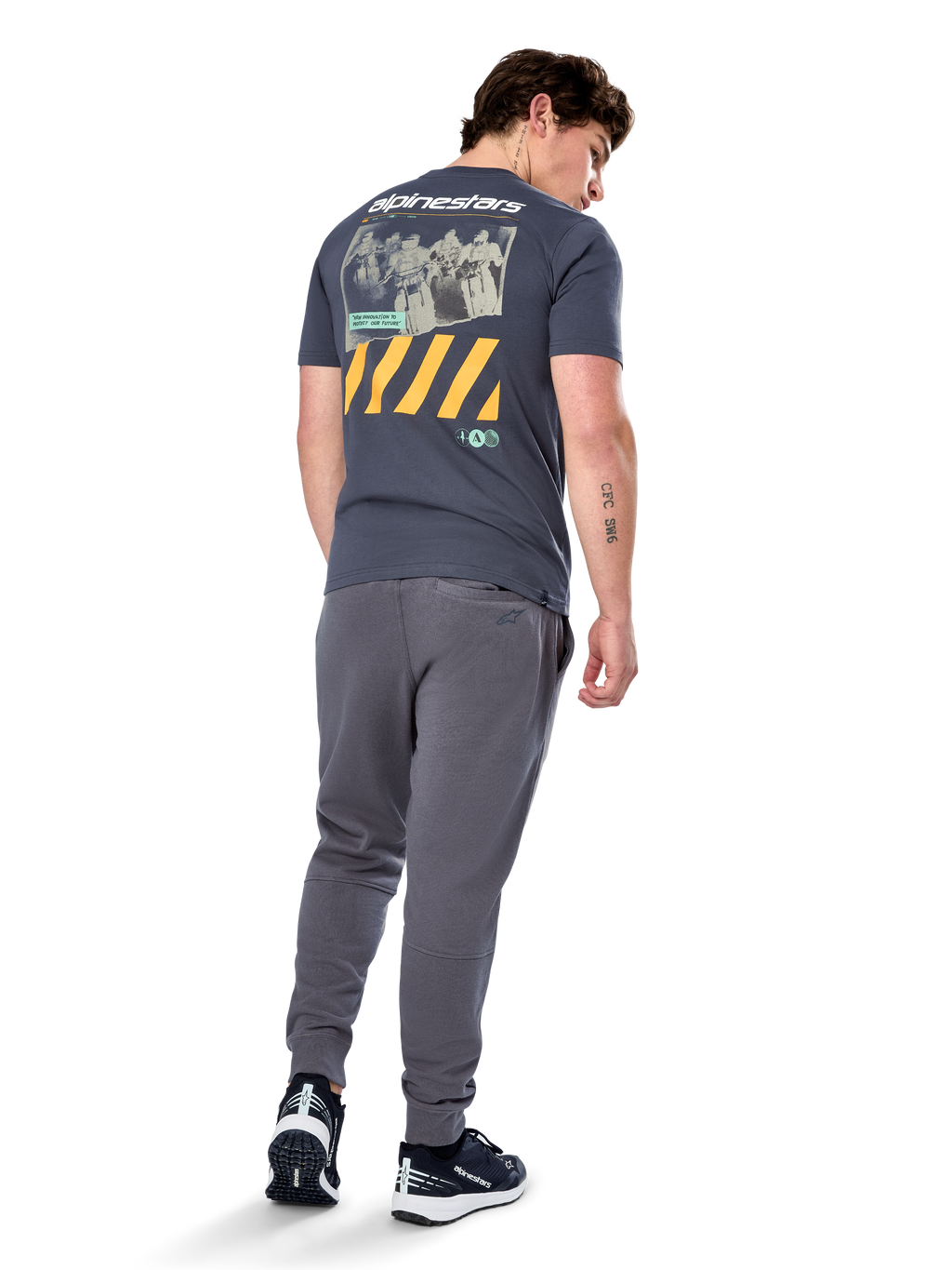 Alpinestars No Barrier CSF Tee, kortärmad t-shirt, Charcoal, vy bakifrån med ett stort slitet fotomotiv, gula diagonala ränder och vit logotyp, vardaglig motorsport-inspirerad streetwear