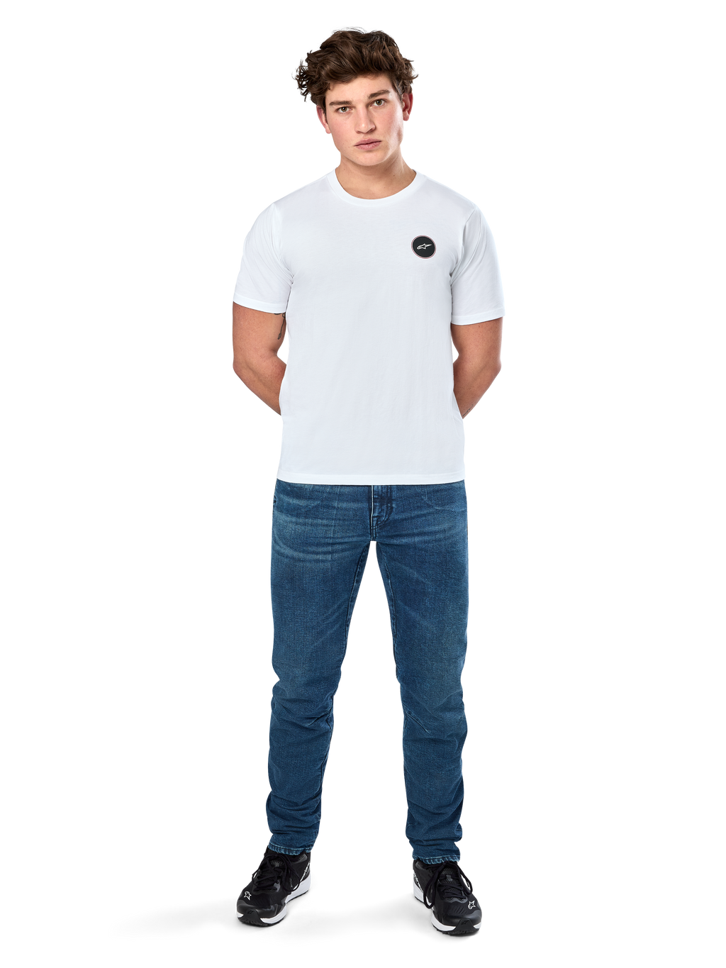 Alpinestars Dot Carbon Csf Tee, kortärmad t-shirt, vit, rund Astars-logotyp med kolfiberutseende, casual motorsport-streetwear, bärs av en manlig modell med blå jeans och svarta sneakers