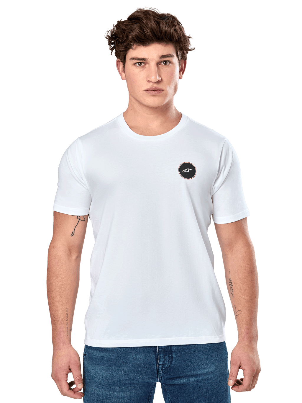 Alpinestars Dot Carbon CSF Tee, vit kortärmad t-shirt, manlig modell i vit t-shirt med liten svart cirkulär logotyp på bröstet och blå jeans, vardaglig motorsportstil