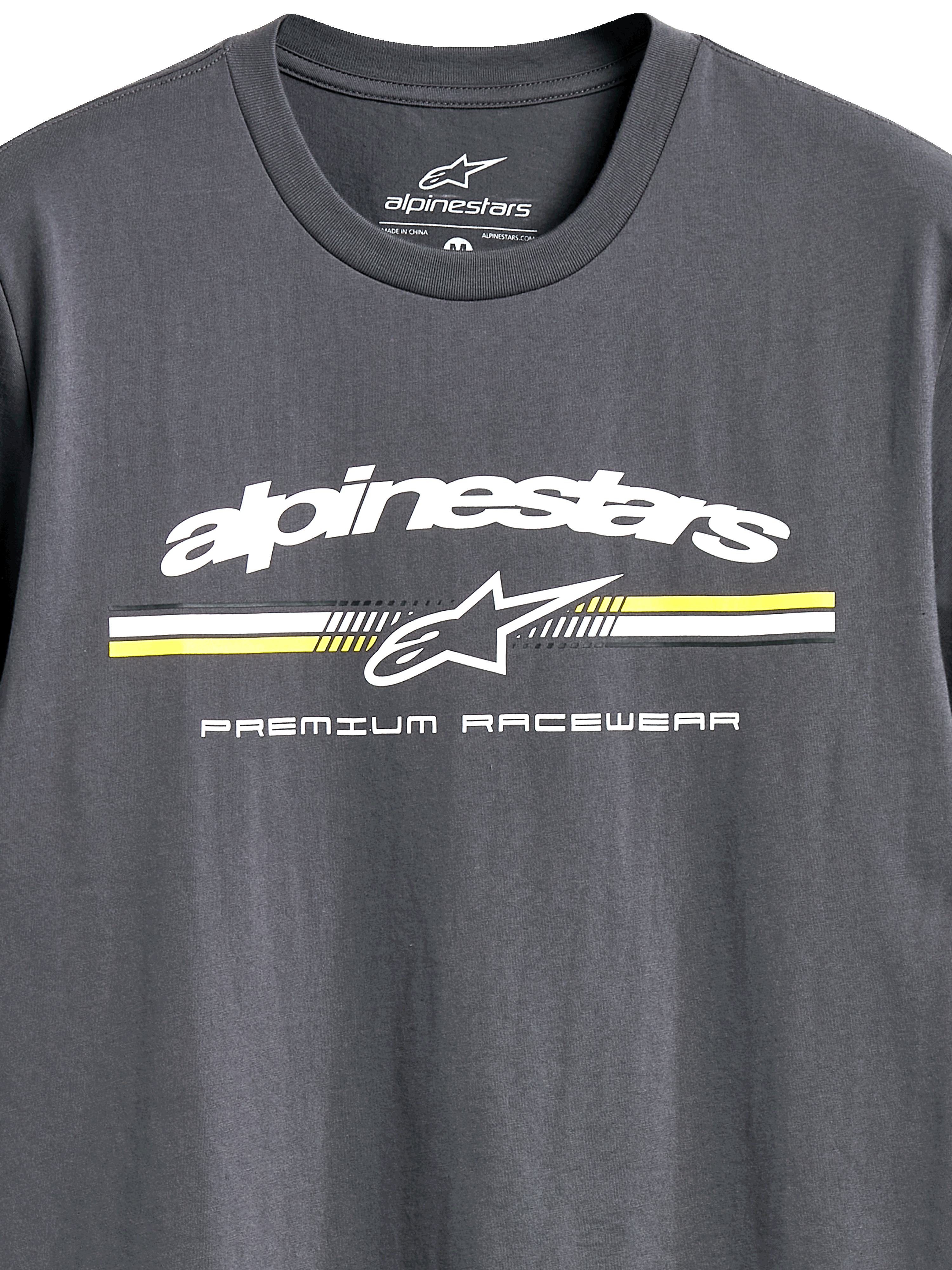 Alpinestars Prevail CSF Tee, kortärmad T-shirt, mörkgrå, vit Alpinestars-logotyp med gula och vita ränder i paddock-stil, 'Premium Racewear'-text, vardagliga motorsportkläder
