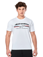 Alpinestars Prevail CSF Tee, vit kortärmad t-shirt med en paddock-inspirerad trefärgad logotyp med röda och blå detaljer, svart Alpinestars-logotyp och texten 'Premium Racewear', bärs av en manlig modell, casual motorsportskläder