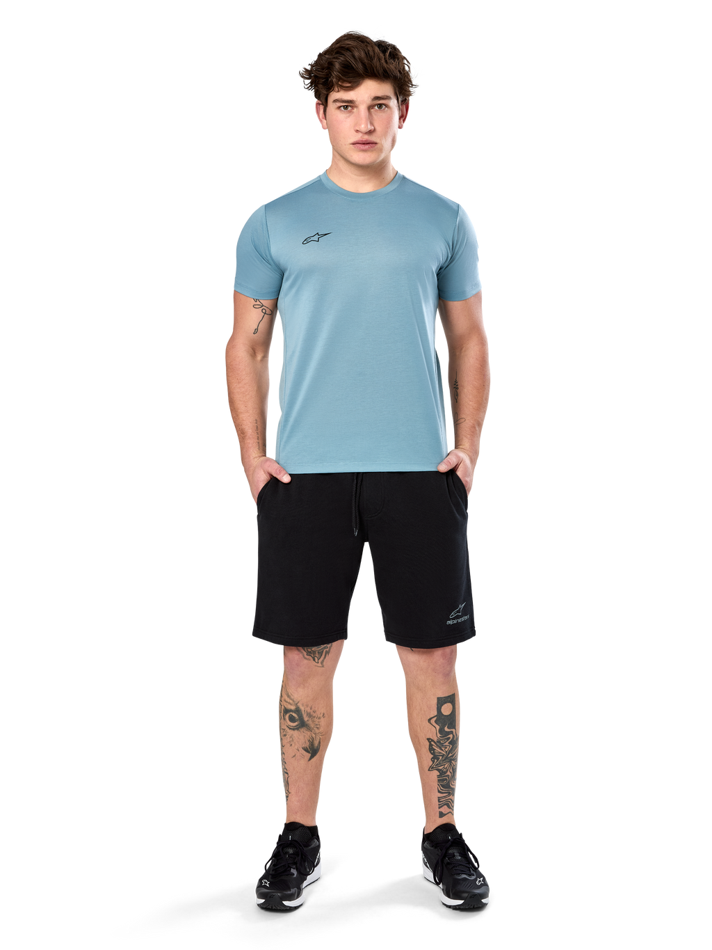 Alpinestars Point Performance Tee, kortärmad T-shirt, Ice Blue, med en liten svart logotyp framtill, rundhalsad, bärs av en modell med svarta shorts och svarta sneakers, avslappnade fukttransporterande sportkläder