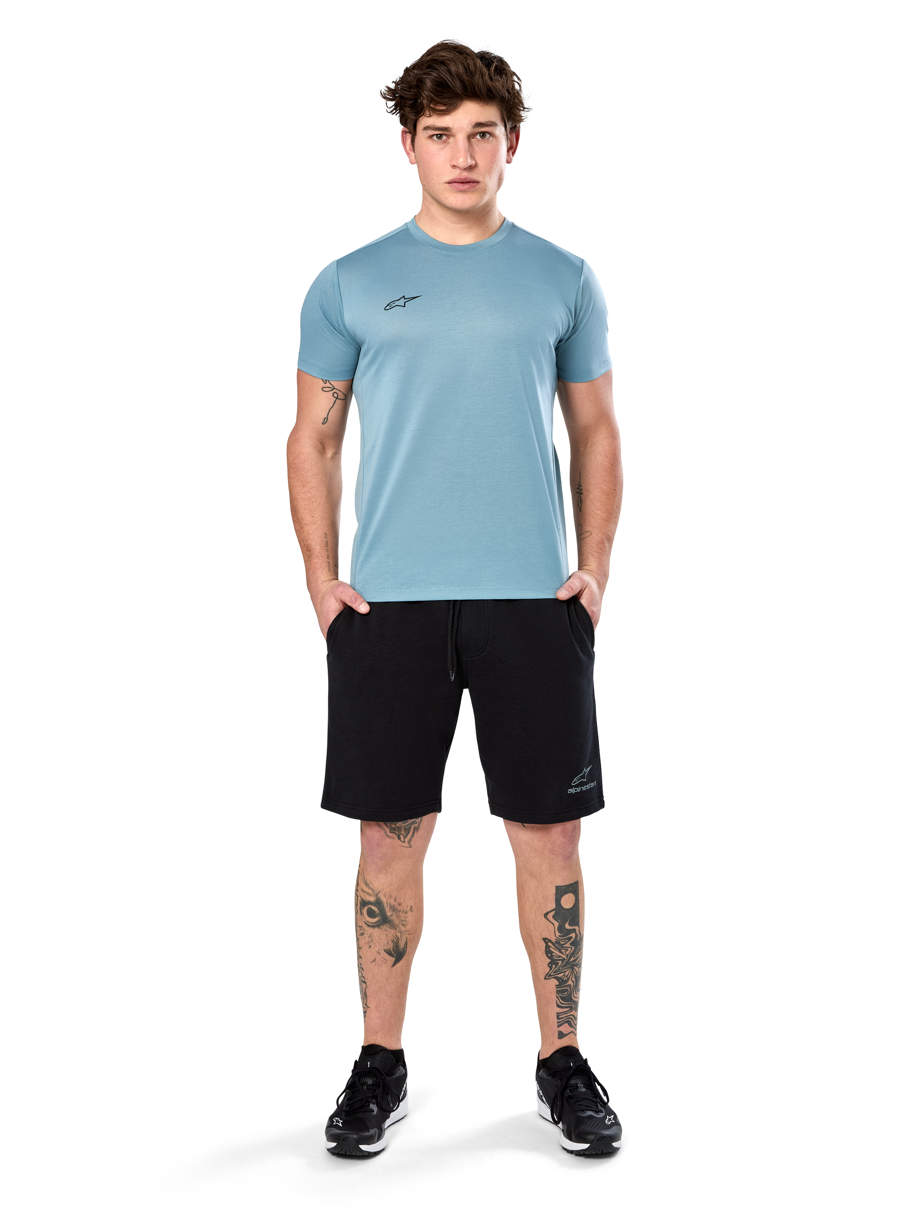 Alpinestars Point Performance Tee, kortärmad T-shirt, Ice Blue, med en liten svart logotyp framtill, rundhalsad, bärs av en modell med svarta shorts och svarta sneakers, avslappnade fukttransporterande sportkläder