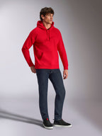 Alpinestars Emergent Oversized huvtröja, röd, fleecehuvtröja med ton-i-ton 3D-broderad logotyp, rymlig passform, bärs av en modell med mörkblå jeans och svarta sneakers, avslappnad motorsportinspirerad streetwear