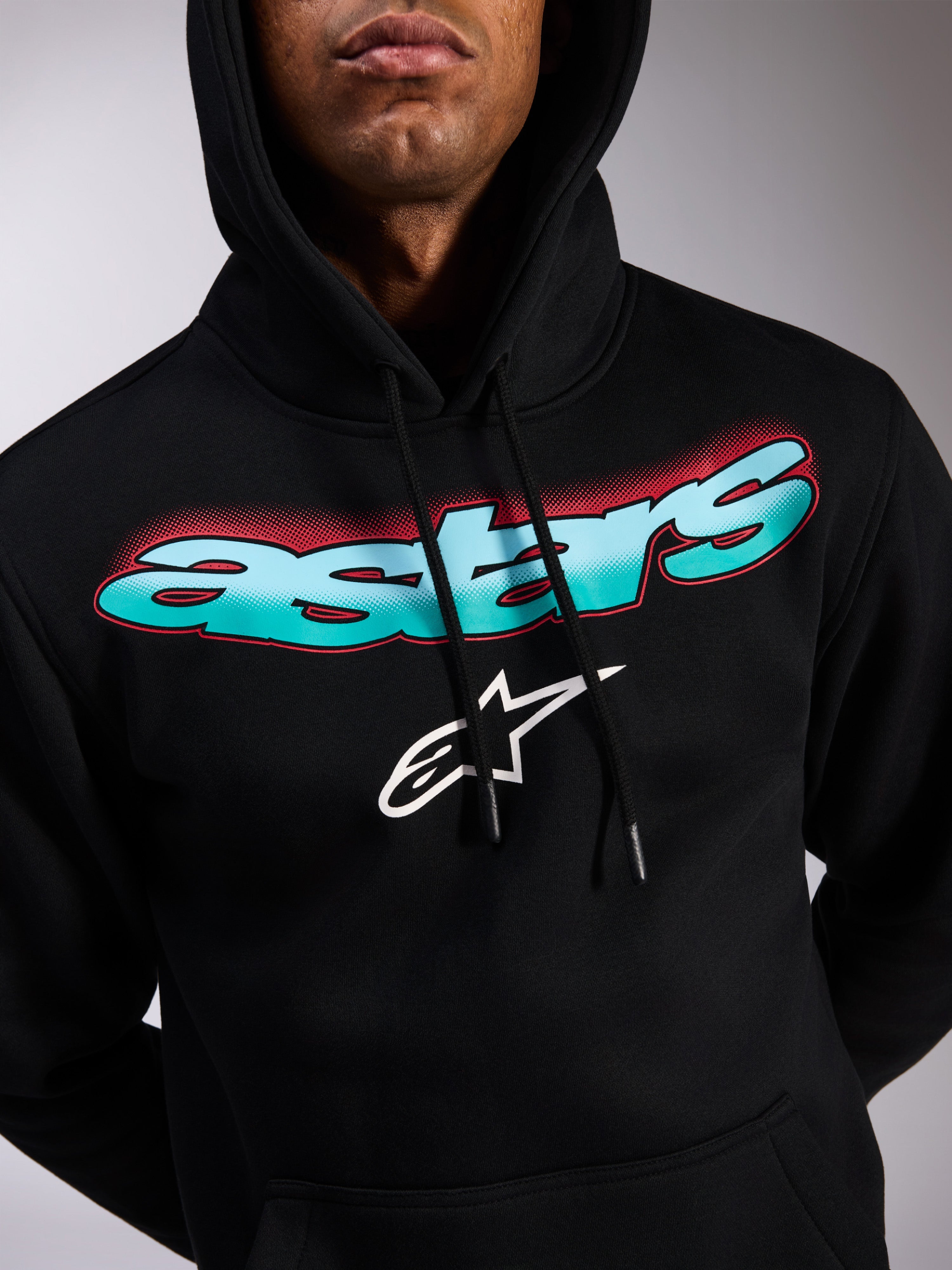 Alpinestars Ellipsoid Hoodie, svart huvtröja i fleece, Astars-ordmärke med färggradient i turkost och blått och röda halftone-detaljer, vit stjärnlogotyp, huva med dragsnöre, avslappnad motorsportinspirerad streetwear