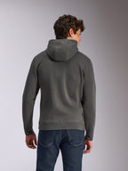 Alpinestars Ellipsoid Hoodie, Gunmetal-grå, vardagliga sportkläder, ryggvy av man som bär huvtröja i fleece, ribbad fåll och muddar, kombinerad med blå jeans