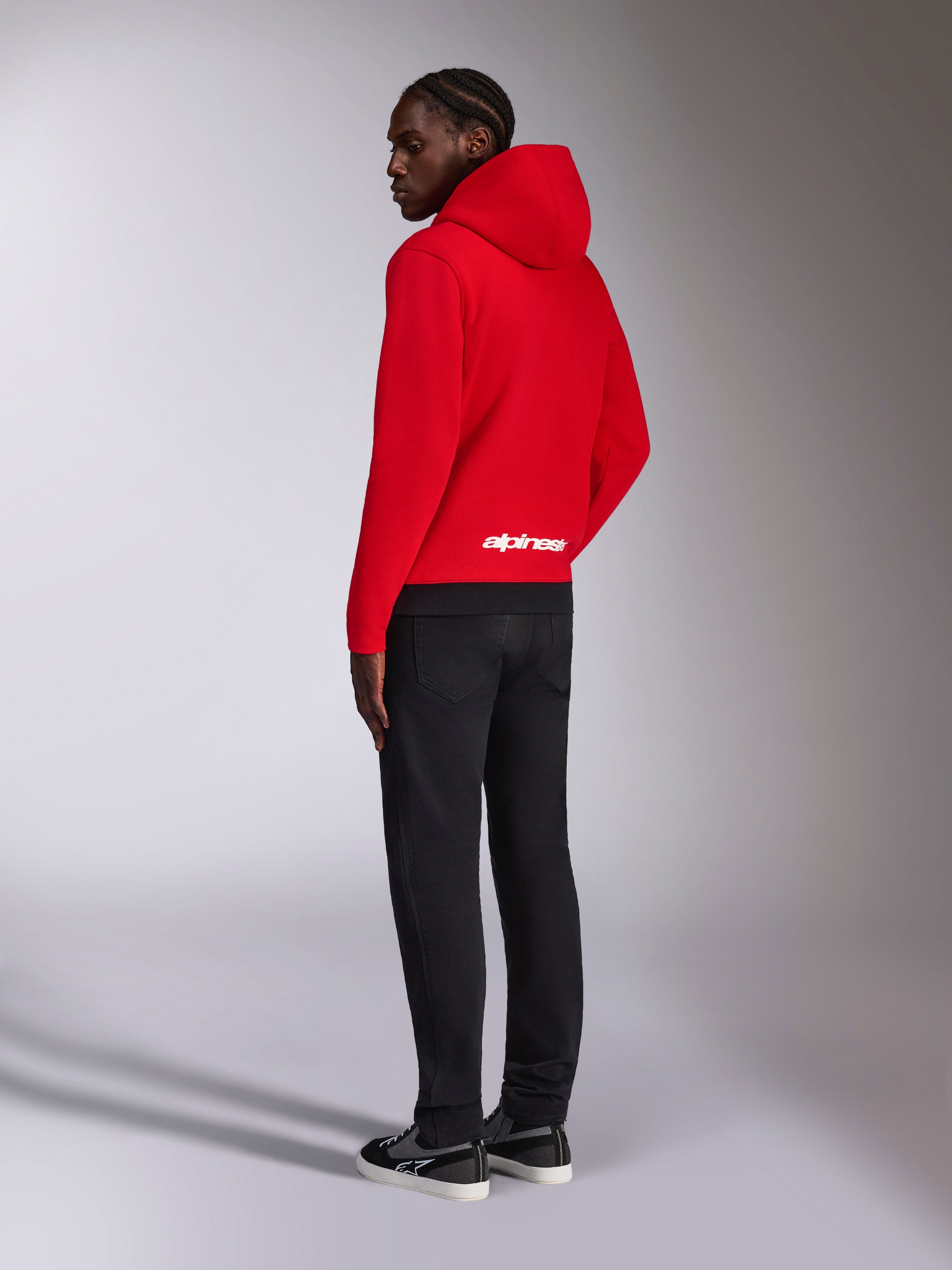 Alpinestars Parallel Huvtröja, ryggvy av röd fleecetröja med svart ribbad fåll, vit Alpinestars-logotyp på nedre delen av ryggen, avslappnad motorsport-streetwearstil