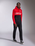 Alpinestars Parallel Hoodie, vardagliga sportkläder, röd och svart färgblockad design, med vit Alpinestars-ordlogga och stjärnlogotyp på bröstet, bärs med svarta byxor och sneakers, modern motorsportinspirerad look