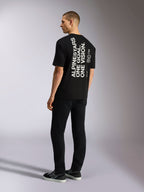 Alpinestars One Oversized CSF Tee, kortärmad t-shirt, svart, ryggvy med vertikalt vitt 'ALPINESTARS ONE GOAL. ONE VISION.'-tryck, oversized passform, avslappnad motorsportinspirerad streetwear