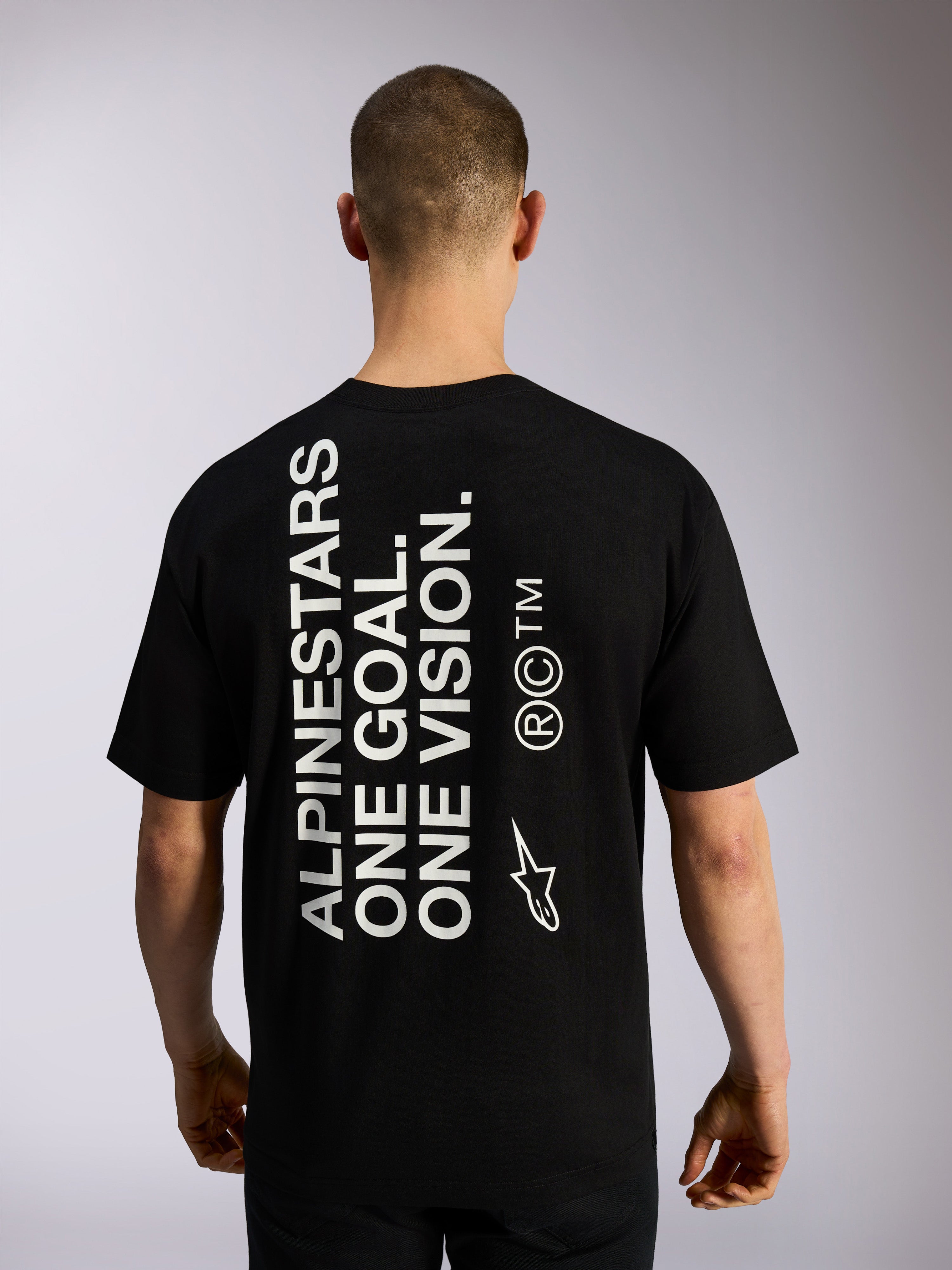 Alpinestars One Oversized CSF Tee, kortärmad t-shirt, svart, vy bakifrån med stor vertikal vit 'ALPINESTARS ONE GOAL. ONE VISION.'-text och logotyper, casual motorsport-streetwear