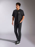 Alpinestars Wild Oversized CSF Tee, Short Sleeve T-Shirt, Black, multi-color Astars logo on the chest, casual streetwear style worn by a model with black pants and high-top sneakers