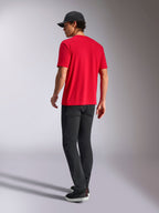 Alpinestars Noka CSF Tee, kortärmad t-shirt, röd, vy bakifrån, stylad med svarta byxor och en svart baseballkeps, avslappnat motorsportinspirerat streetwear