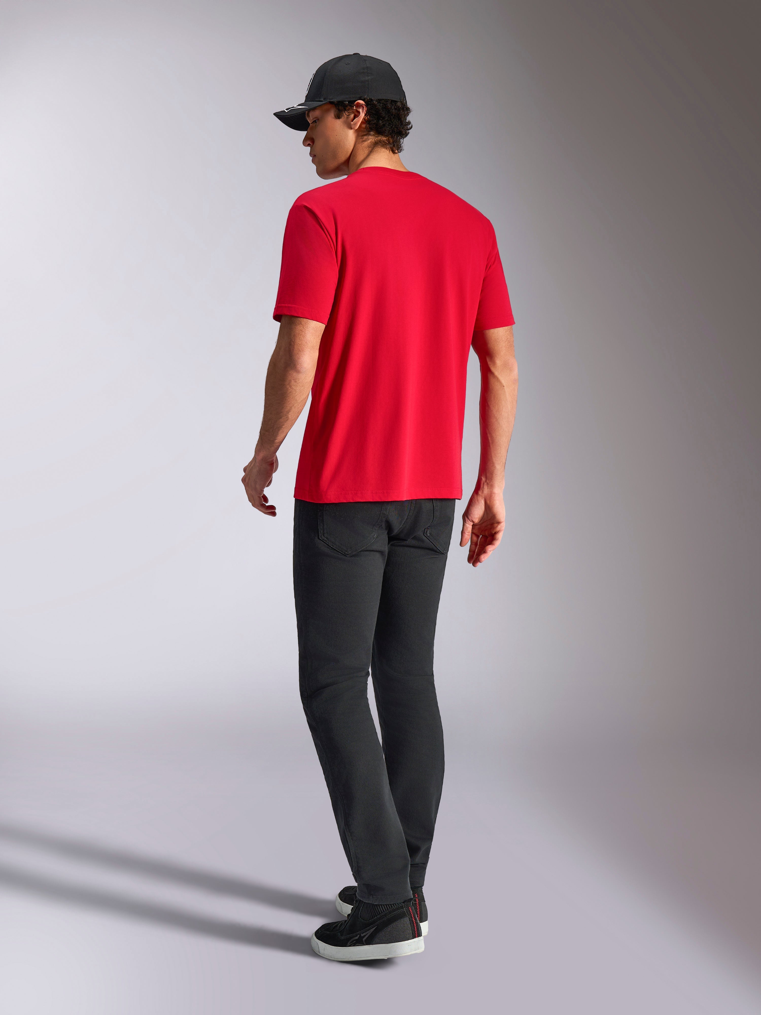 Alpinestars Noka CSF Tee, kortärmad t-shirt, röd, vy bakifrån, stylad med svarta byxor och en svart baseballkeps, avslappnat motorsportinspirerat streetwear