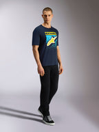 Alpinestars Noka CSF Tee, kortärmad t-shirt, marinblå, gul Astars-logotyp med blå MX-graderad grafik, manlig modell i marinblå t-shirt, svarta byxor och sneakers, avslappnad motorsport-streetwear