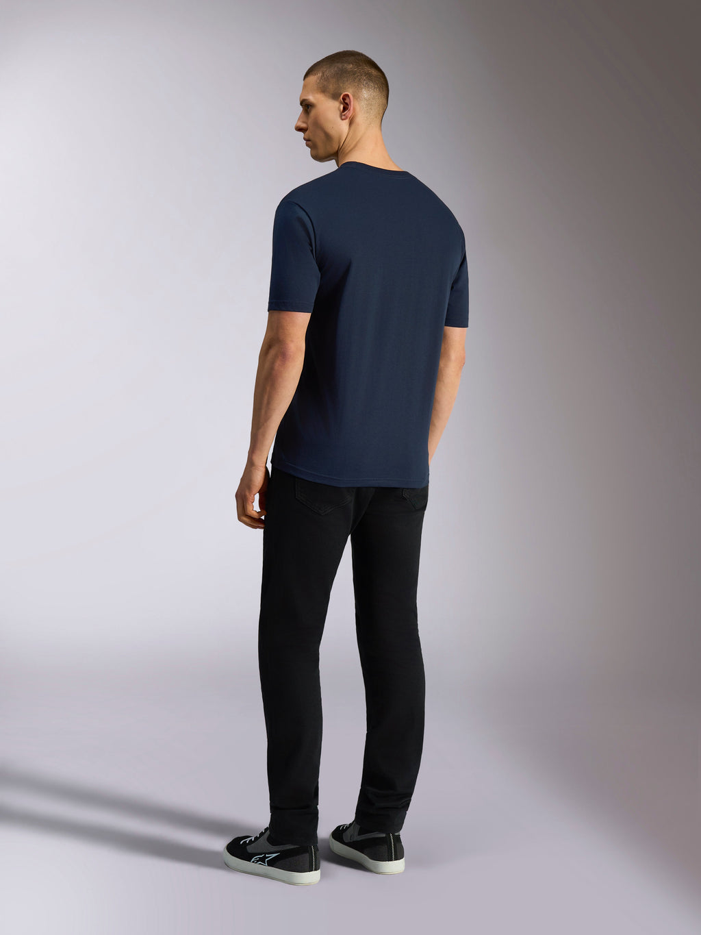 Alpinestars Noka CSF Tee, kortärmad t-shirt, marinblå, baksida visas på modell som bär svarta byxor och sneakers, avslappnad motorsport-streetwear