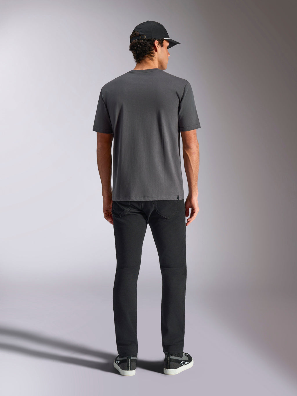 Alpinestars Ellipsoid CSF Tee, kortärmad t-shirt, mörkgrå, sedd bakifrån på modell med svart keps och byxor, avslappnad streetwear