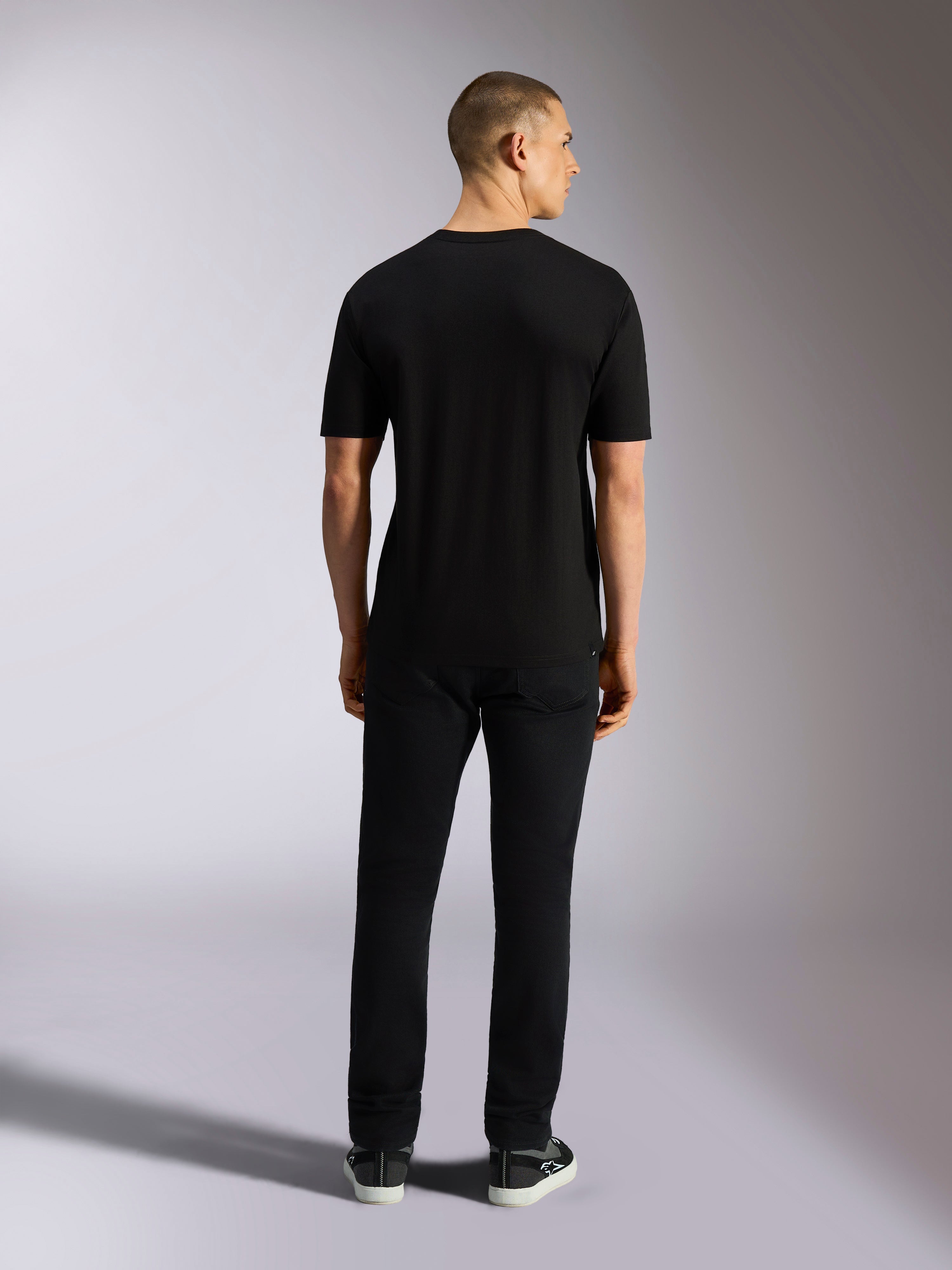 Alpinestars MX CSF Tee, kortärmad t-shirt, svart, bakifrån på modell med svarta byxor, vardagliga motorsportinspirerade kläder