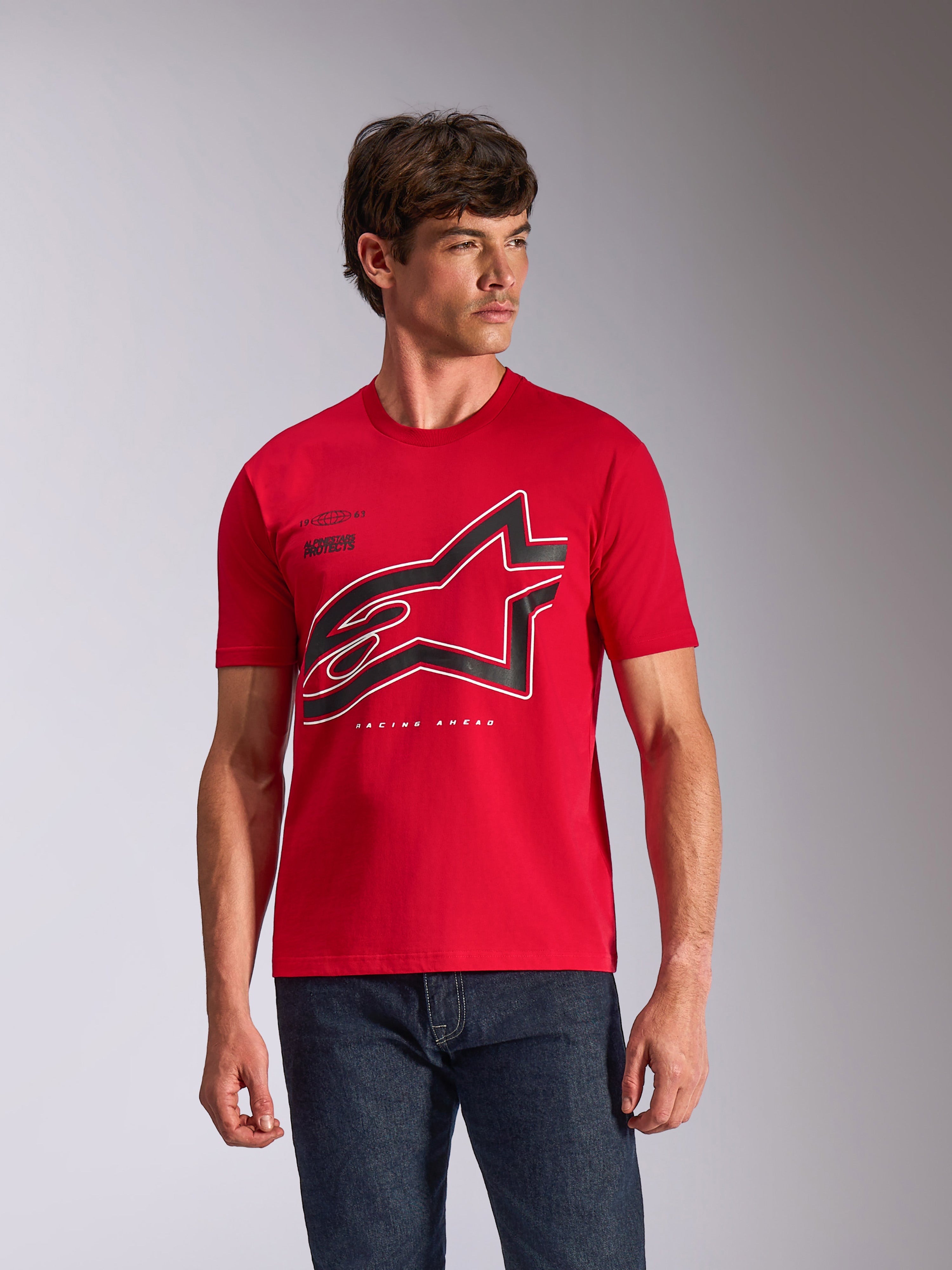 Alpinestars Authority CSF Tee, kortärmad t-shirt, röd, stor svart och vit konturerad Astars-logotyp på bröstet, bärs av en manlig modell med mörkblå jeans, avslappnad motorsport-inspirerad streetwear