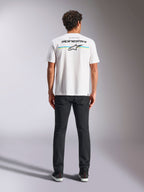 Alpinestars Lanes CSF Tee, kortärmad t-shirt, vit, ryggvy på modell med Alpinestars-logotyp och Astars-stjärna över horisontella blå och gula ränder, avslappnad motorsport-streetwear