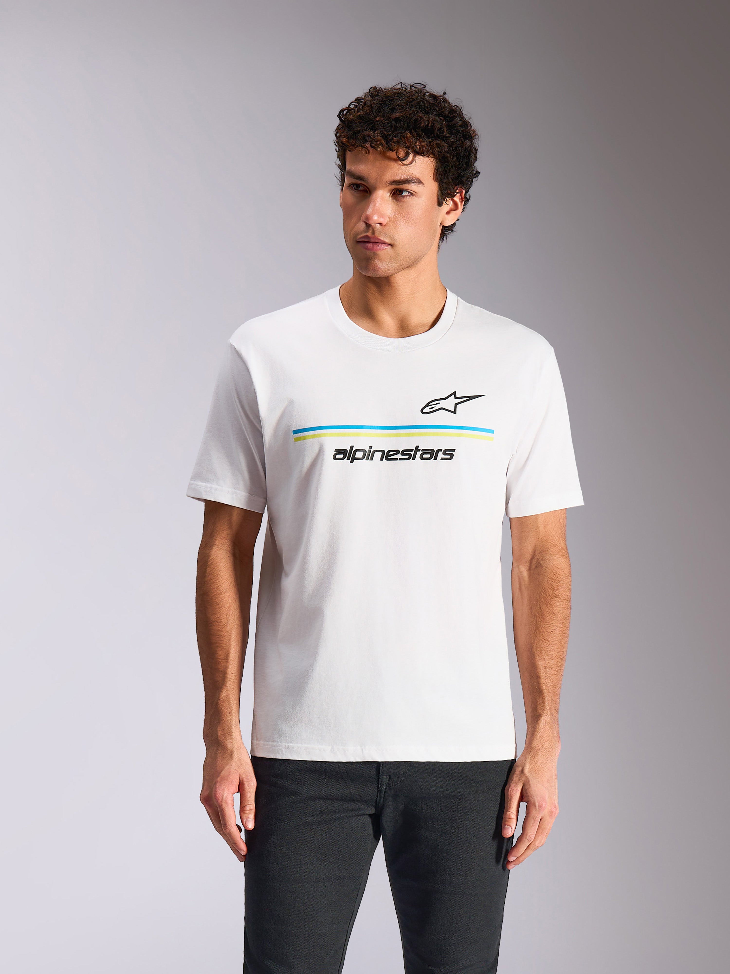 Alpinestars Lanes CSF Tee, kortärmad t-shirt, vit, med svart Astars-logotyp ovanför blå och limegröna horisontella ränder och "alpinestars"-text, bärs av modell, avslappnad motorsport-streetwear