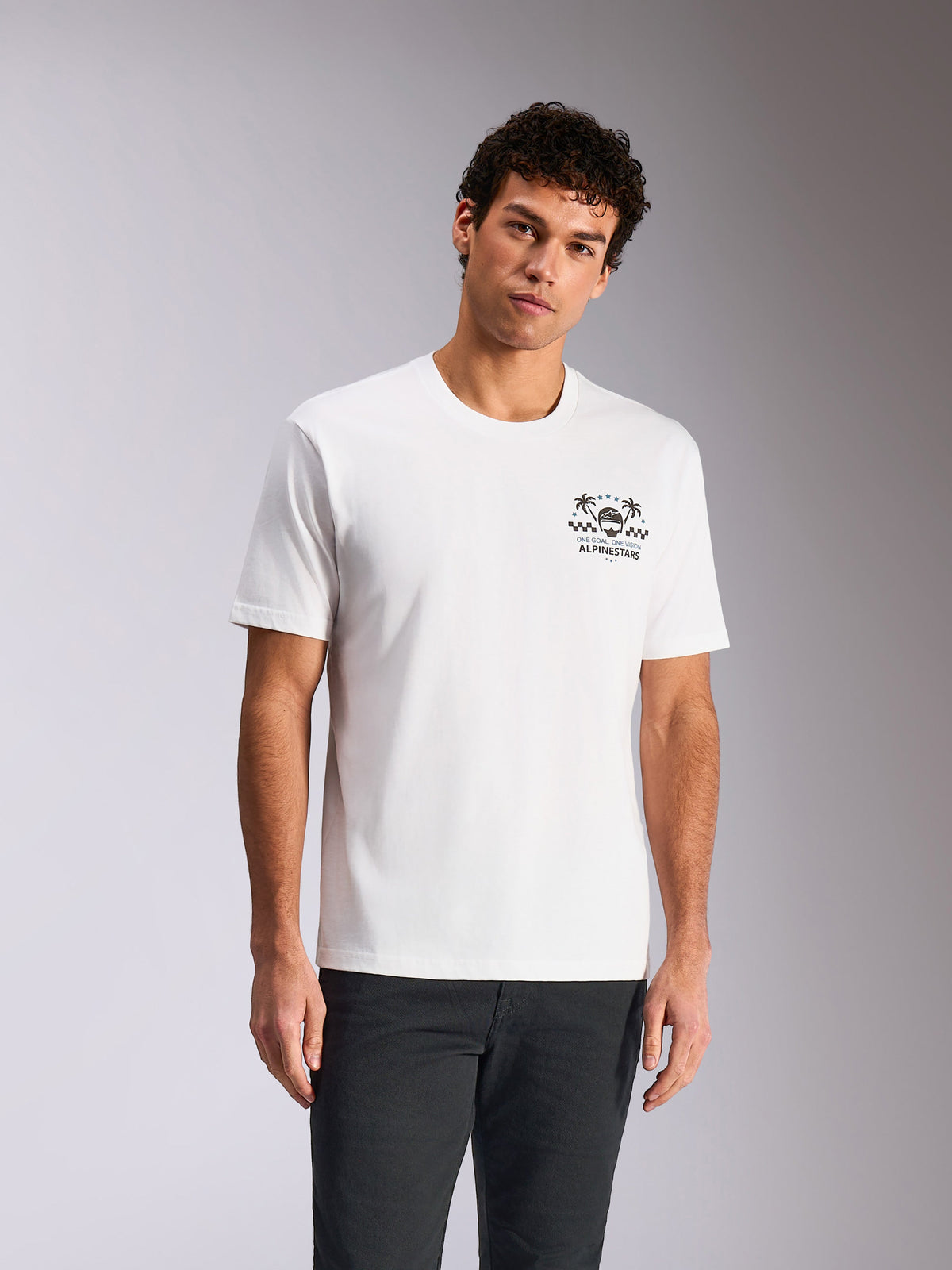 Alpinestars Order CSF Tee, kortärmad t-shirt, vit, bröstgrafik med hjälm och palmträd, bärs av modell med mörka byxor, avslappnad motorsportinspirerad streetwear