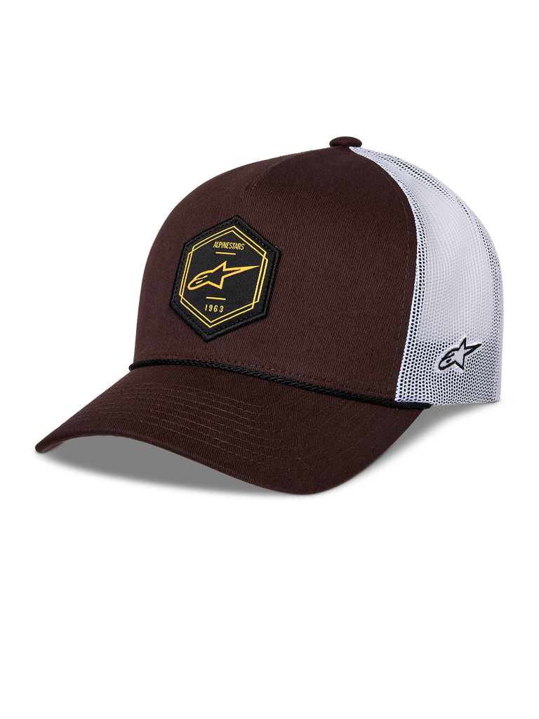 Alpinestars Hexeon Trucker Hat, brun och vit keps med böjd skärm, strukturerad mörkbrun framsida och vit meshbaksida, svart hexagonformat märke fram med gul logotyp, broderad logotyp på sidan och klassisk trucker-stil.