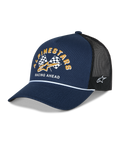 Alpinestars Finisher Trucker Hat, Navy Blue and Black, curved bill with white rope detail, front Alpinestars checker flags graphic with gold logo and "Racing Ahead" text, side Astars logo embroidery, casual motorsport headwear.