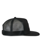 Alpinestars Contender Trucker-keps, svart truckerkeps, profilvy från sidan, med platt skärm och ventilerande meshpaneler baktill, snapback-stängning, avslappnad motorsportstil