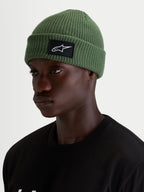 Alpinestars Unload Rib Cuff Beanie, casual winter beanie in pea green, worn by a model, featuring a knit jersey stitch construction and a black and white SAstars woven front patch