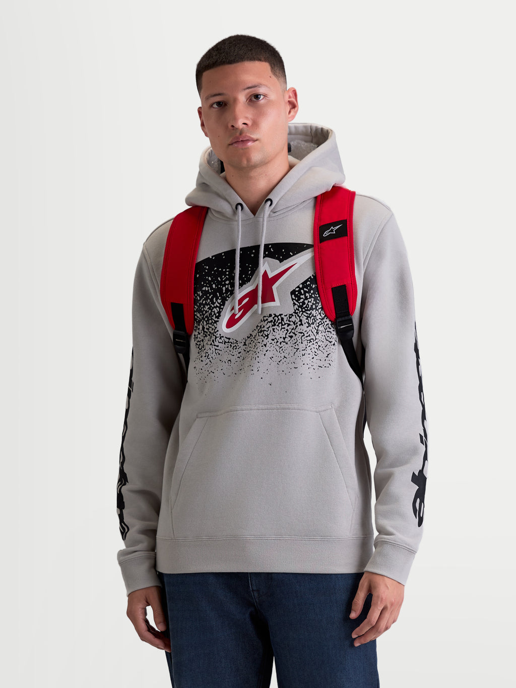 Alpinestars GFX Boss ryggsäck, 20L urban sportswear-ryggsäck för herr och dam, röd och svart, slitstark 600D polyester, frontvy på modell med justerbara axelremmar i luftmesh och upphöjd silikonlogotyp.