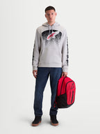Alpinestars GFX Boss ryggsäck, röd och svart sportryggsäck, 20L kapacitet, slitstark 600D polyester med upphöjd Astars-logotyp i silikon, hålls av en manlig modell för urban vardagsanvändning.