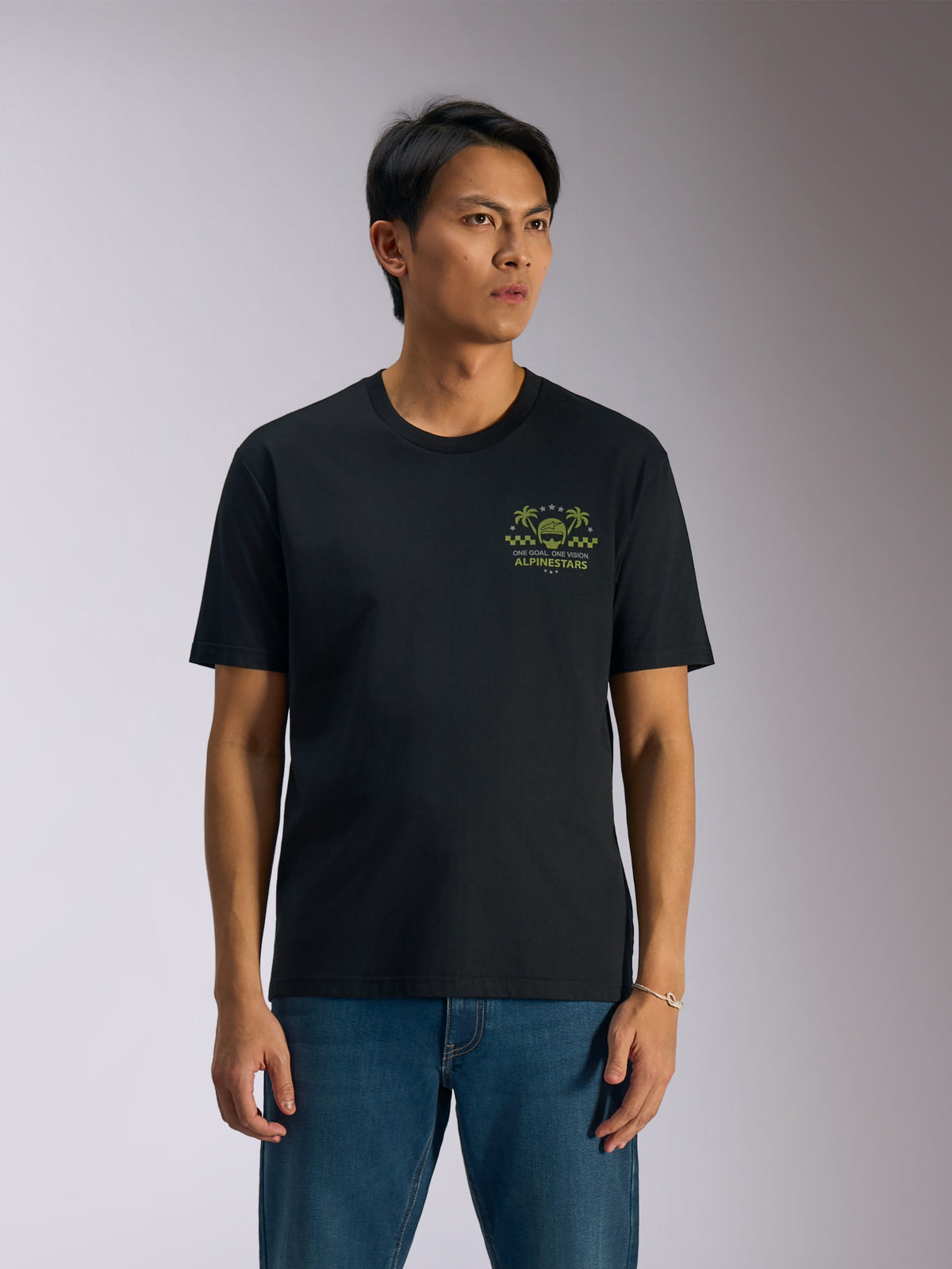 Alpinestars Order CSF Tee, kortärmad t-shirt, svart, grön grafik med hjälm och palmträd på bröstet, blå jeans, casual motorsport-streetwear