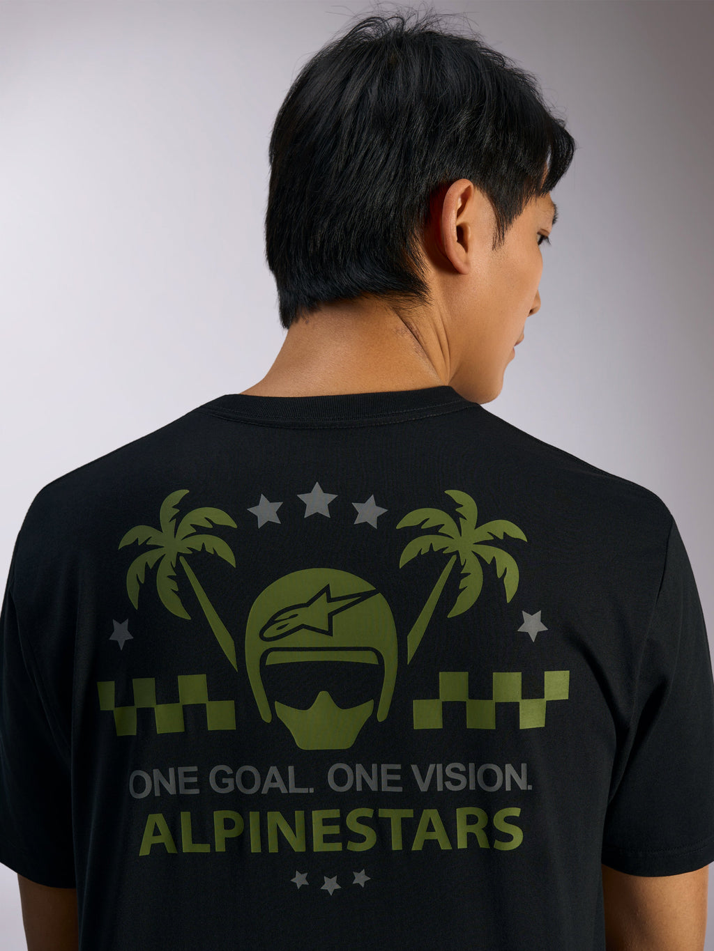 Alpinestars Order CSF Tee, kortärmad t-shirt, svart, baksida med grön hjälm- och palmträdgrafik, grå stjärnor och texten 'ONE GOAL. ONE VISION. ALPINESTARS', casual motorsport-streetwear