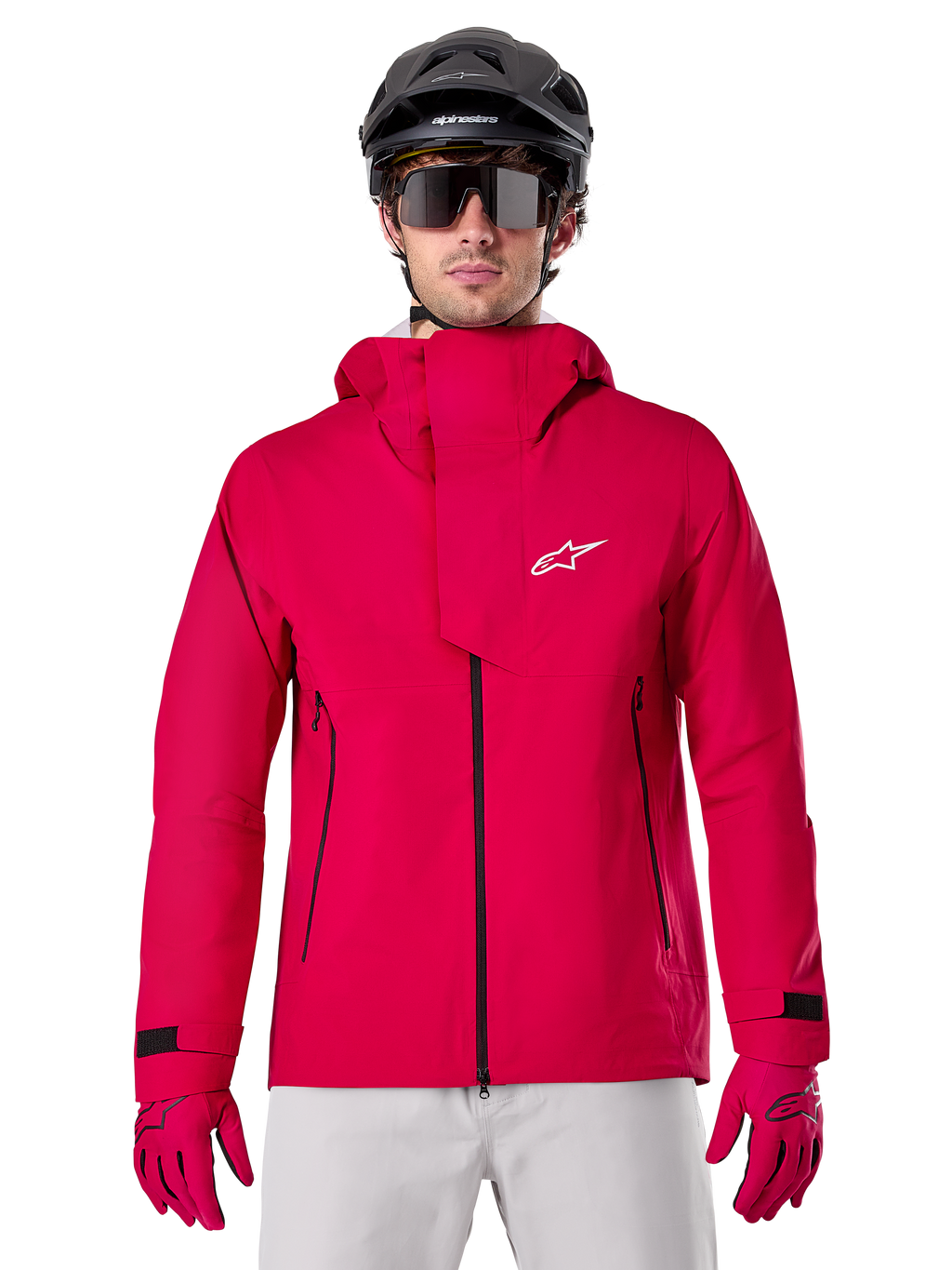 Alpinestars A-Dura Elite Waterproof Jacket, regnjacka för mountainbike, Red Fluo, hög krage med vit Alpinestars-logotyp, svarta dragkedjedetaljer, bärs med matchande handskar och svart cykelhjälm, teknisk vattentät cykelutrustning