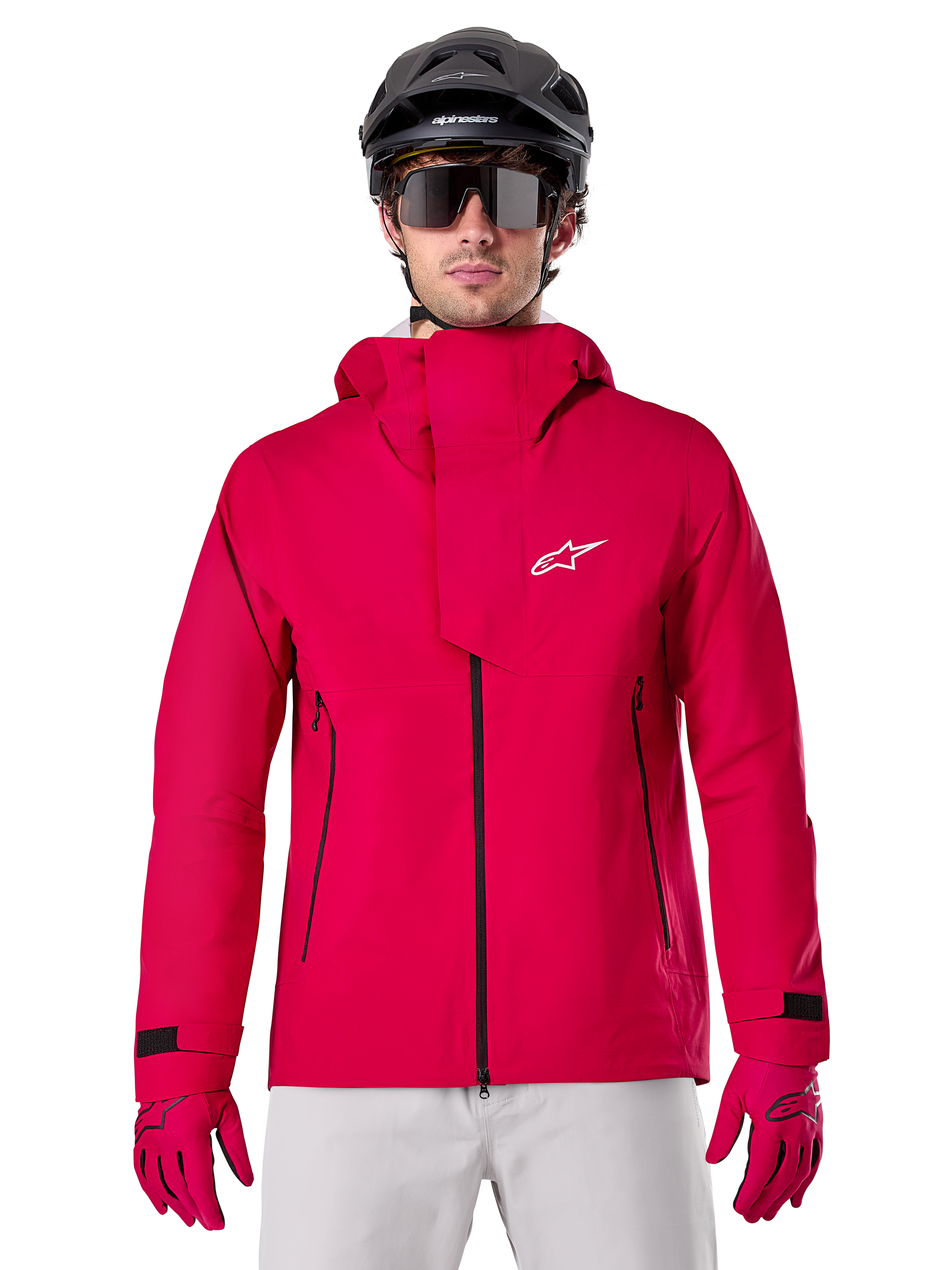 Alpinestars A-Dura Elite Waterproof Jacket, regnjacka för mountainbike, Red Fluo, hög krage med vit Alpinestars-logotyp, svarta dragkedjedetaljer, bärs med matchande handskar och svart cykelhjälm, teknisk vattentät cykelutrustning