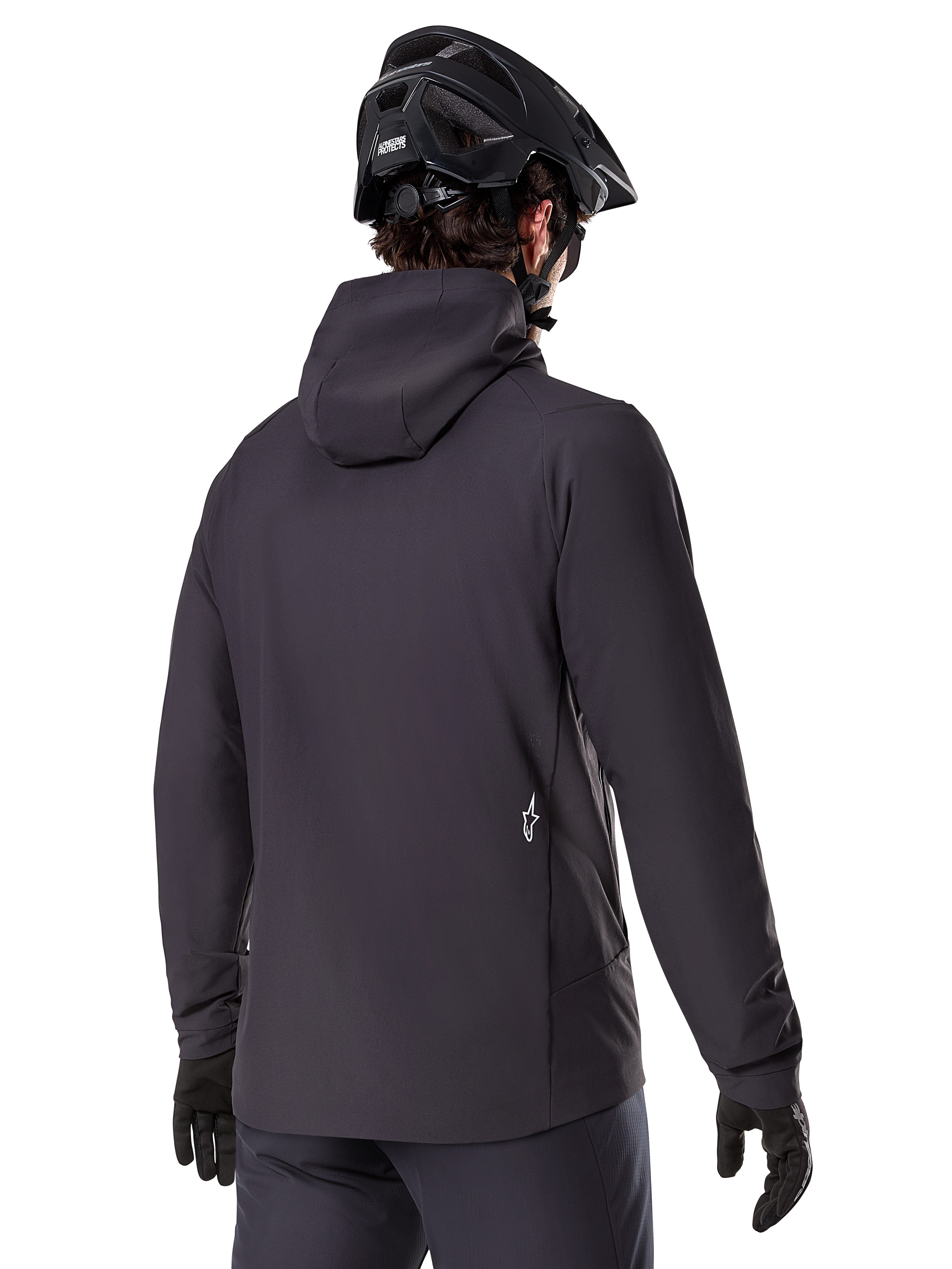 Alpinestars A-Dura Thermal Jacket, svart, vy bakifrån, bärs med en svart mountainbikehjälm och handskar, har en liten vit Astars-logotyp på nedre delen av ryggen, lätt isolerad cykeljacka