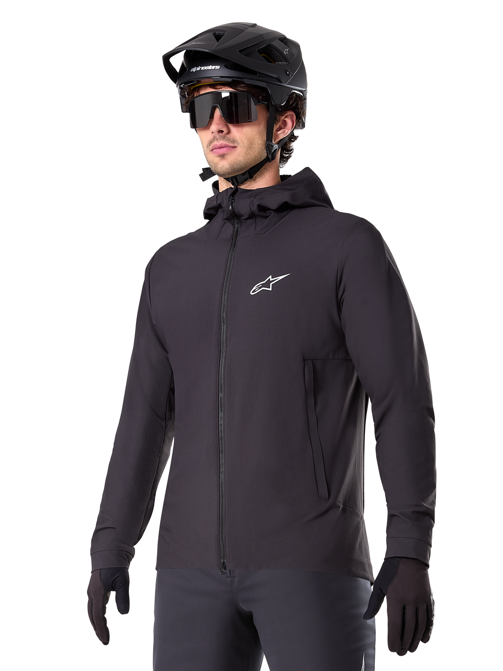 Alpinestars A-Dura Thermal Jacket, svart cykeljacka, design med huva och dragkedja framtill, vit stjärnlogotyp på bröstet, bärs med svart mountainbikehjälm och handskar, sportig funktionsutrustning för terrängcykling i kallt väder