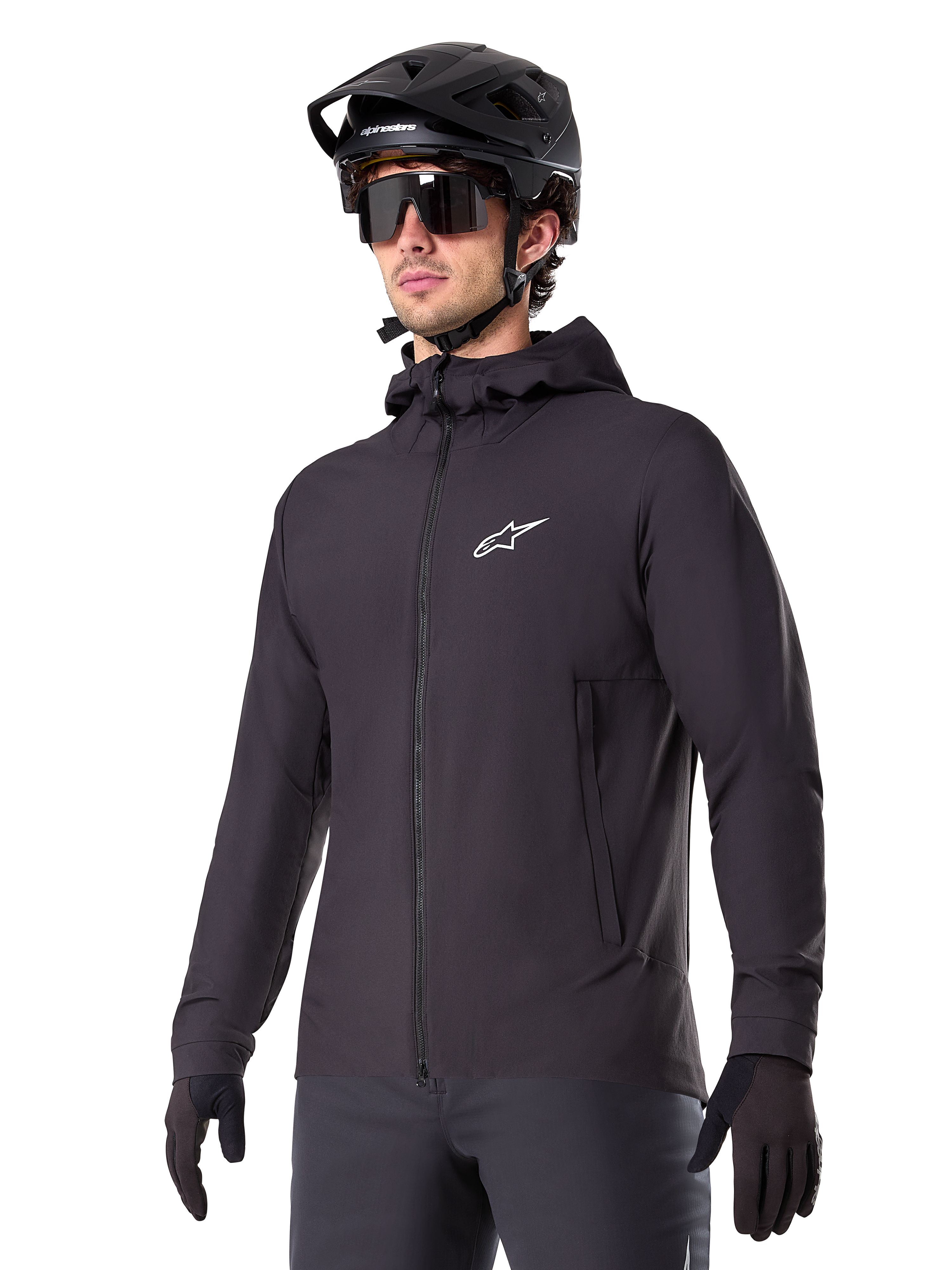 Alpinestars A-Dura Thermal Jacket, svart cykeljacka, design med huva och dragkedja framtill, vit stjärnlogotyp på bröstet, bärs med svart mountainbikehjälm och handskar, sportig funktionsutrustning för terrängcykling i kallt väder