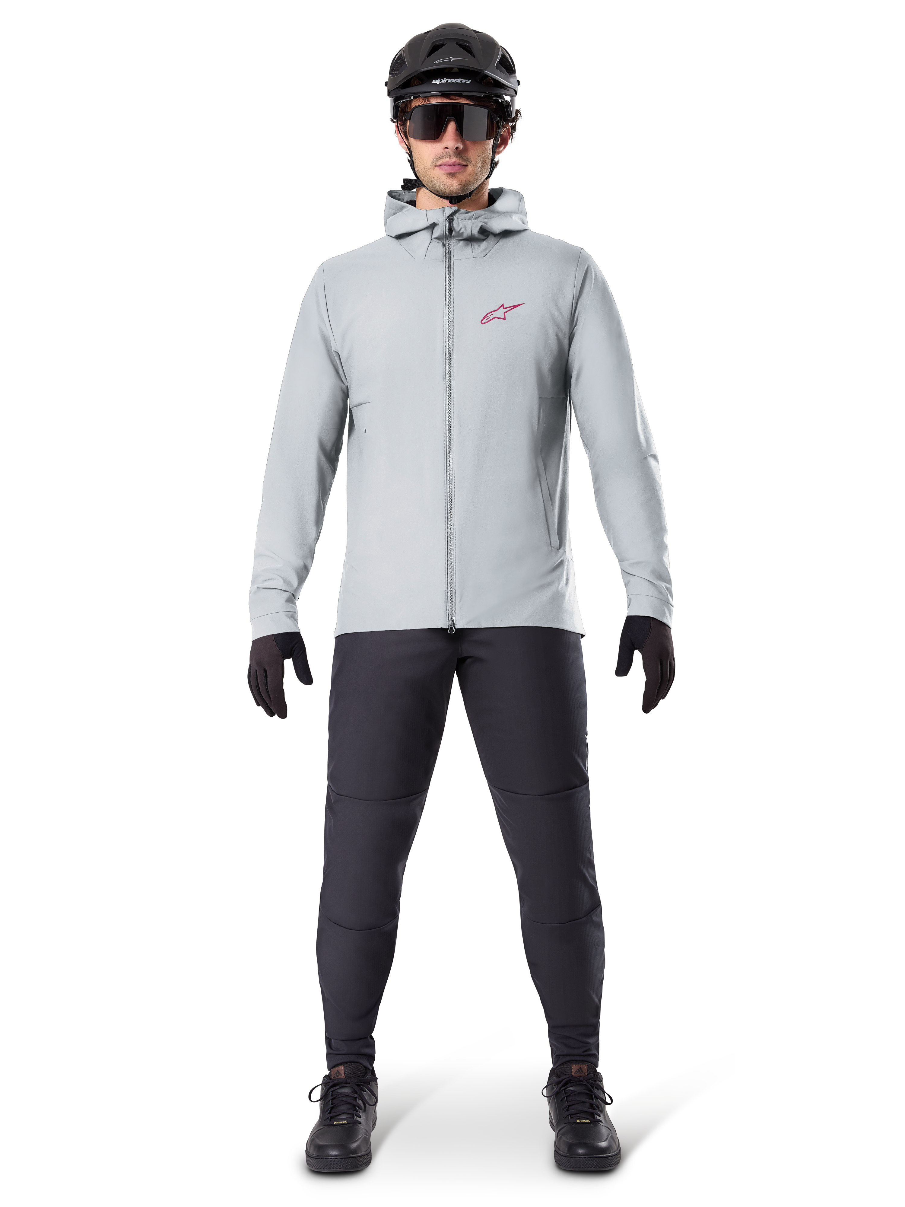 Alpinestars A-Dura Thermal Jacka, titaniumgrå, cykeljacka bärs med svarta mountainbikebyxor, handskar och hjälm, med en liten röd stjärnlogotyp på bröstet och hel dragkedja fram, lätt isolerad utrustning för terrängkörning