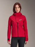 Alpinestars Stella A-Dura Elite Waterproof Jacket, mountainbikejacka för dam, röd (Red Fluo), design med huva och asymmetrisk vindslå, vit Alpinestars-logotyp på bröstet, justerbara svarta manschetter, bärs av en kvinnlig modell med svarta byxor