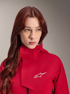 Alpinestars Stella A-Dura Elite vattentät jacka, Red Fluo, bärs av en kvinna med långt rött hår, teknisk 3-lagers vattentät jacka med hög krage och vit logotyp, högpresterande outdoor- och mountainbikeutrustning
