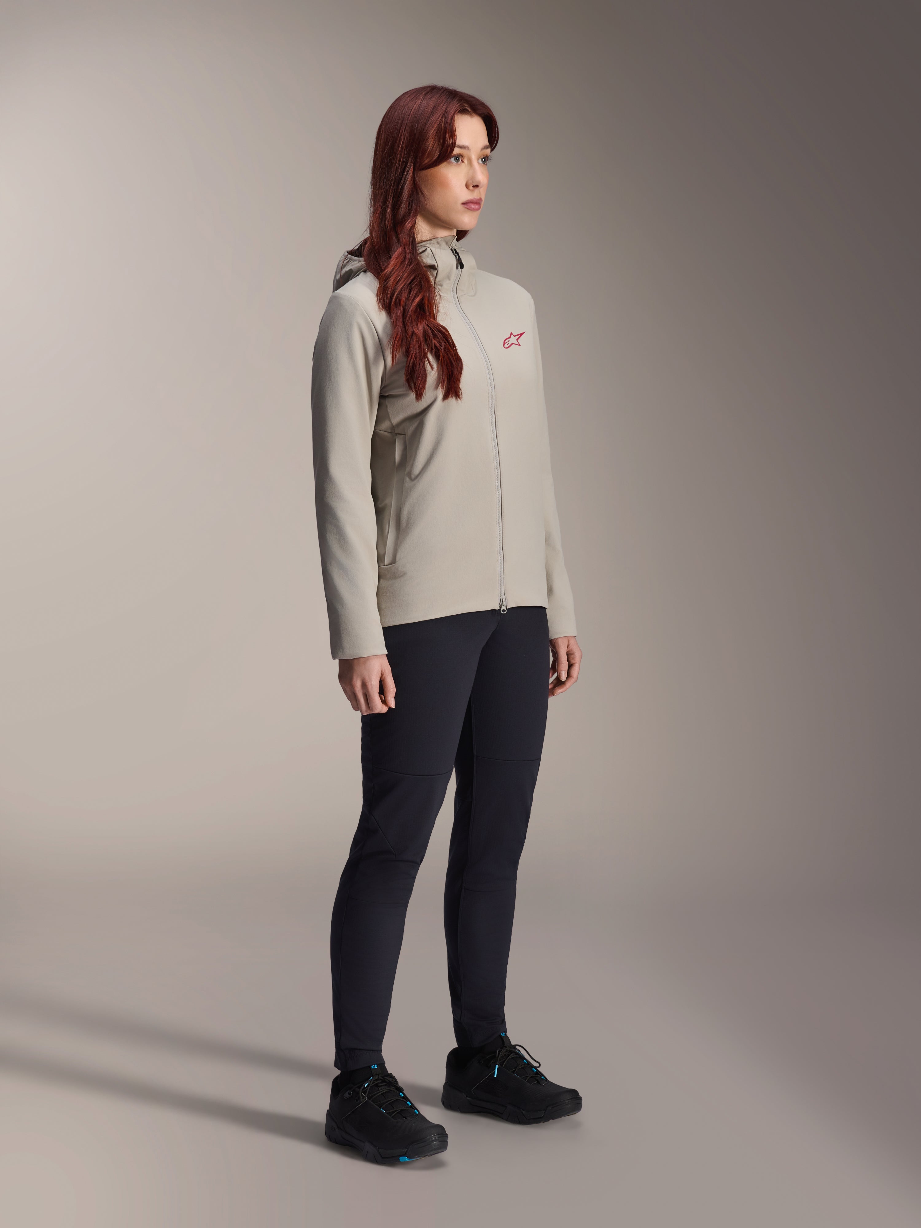Alpinestars Stella A-Dura Thermal Jacket, Titanium-grå, termojacka för damcykling med en röd stjärnlogotyp på bröstet, bärs med svarta tekniska byxor och svarta mountainbikeskor, studiobild för cykelkläder