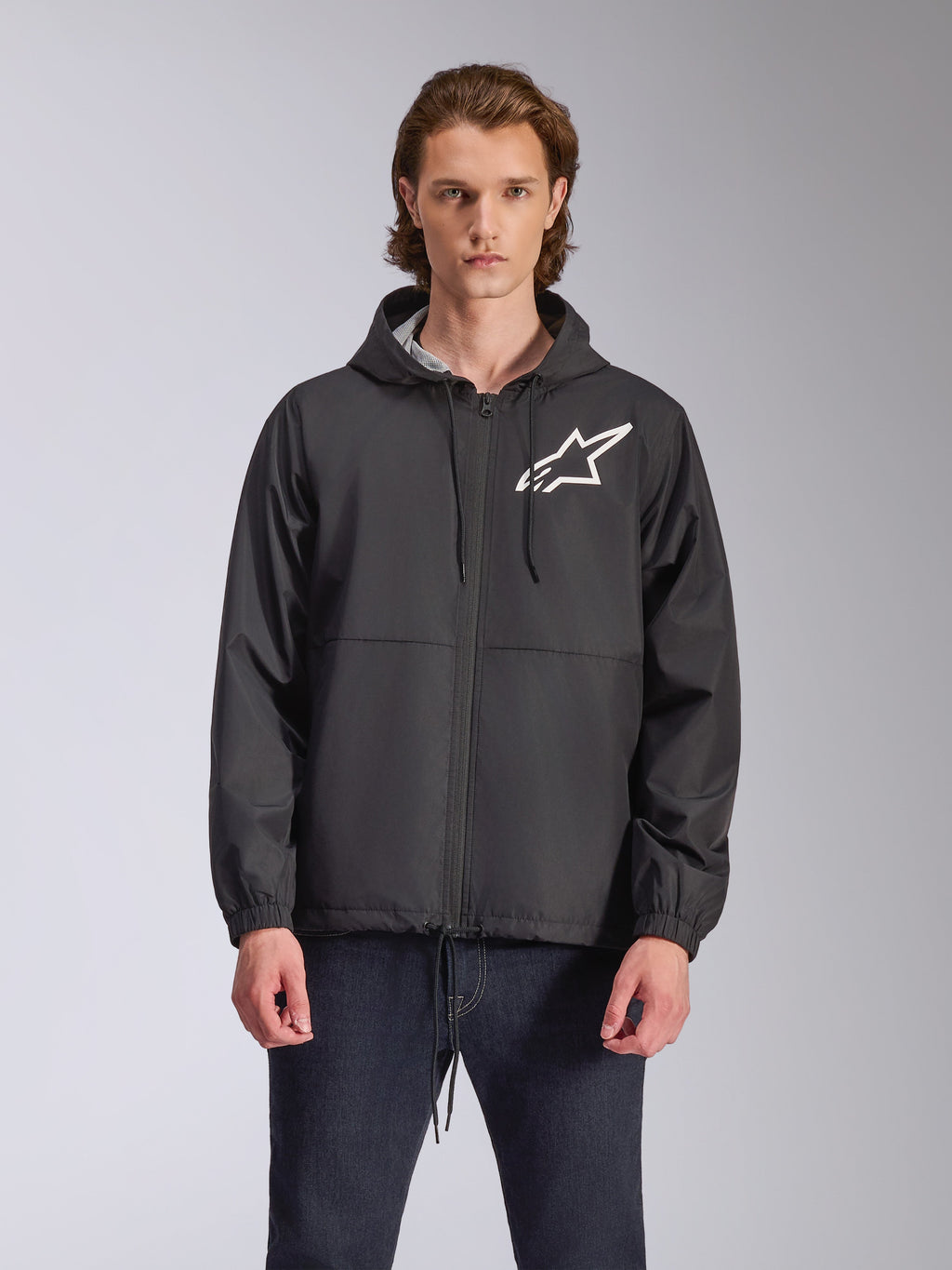 Alpinestars Speeder Chromium vindjacka, svart jacka med huva och vit stjärnlogotyp på bröstet, med dragkedja fram, huva med dragsnören och elastiska muddar, motorsport-inspirerat avslappnat streetwear