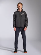 Alpinestars Speeder Chromium vindjacka, svart med vit Astars-logotyp, bärs av modell med mörkblå jeans och svarta sneakers, med huva och dragkedja fram, avslappnad motorsportinspirerad streetwear