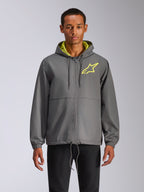 Alpinestars Speeder Chromium Windbreak Jacket, mörkgrå vindjacka med huva och neongul stjärnlogotyp, limegrön insida i huvan, elastiska muddar, justerbara dragskor, dragkedja framtill, avslappnad motorsportstil